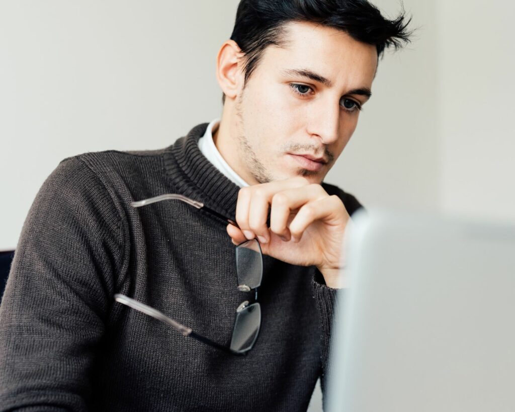 Jeune homme avec ses lunettes à la main