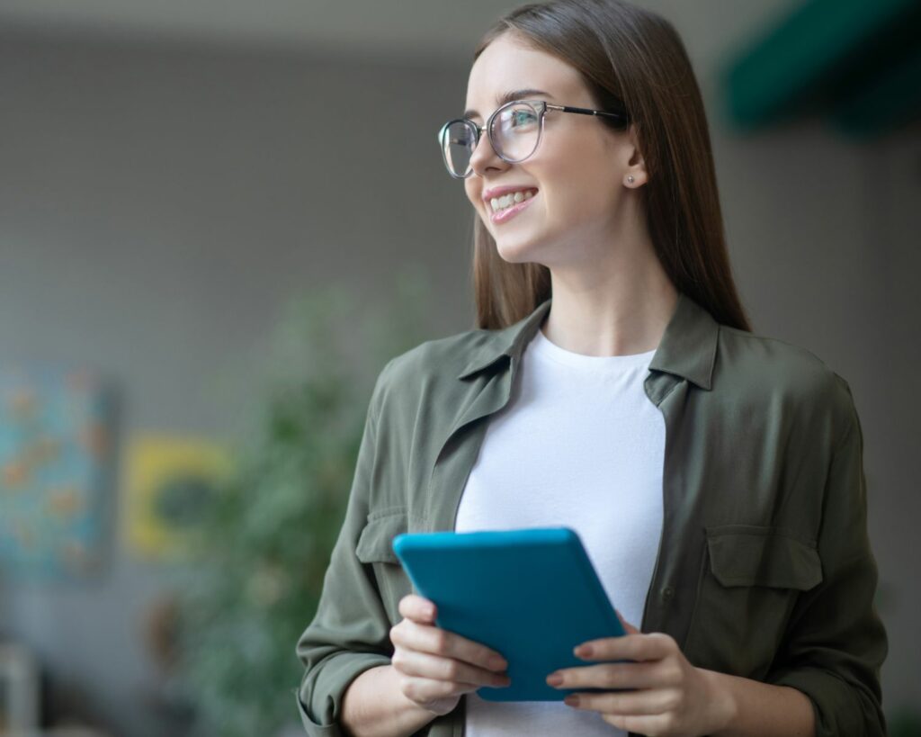 Jeune fille avec des lunettes et une tablette tactile à la main