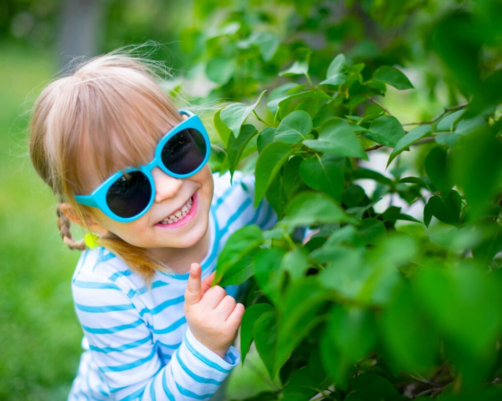 Petite fille portant des lunettes de soleil bleues