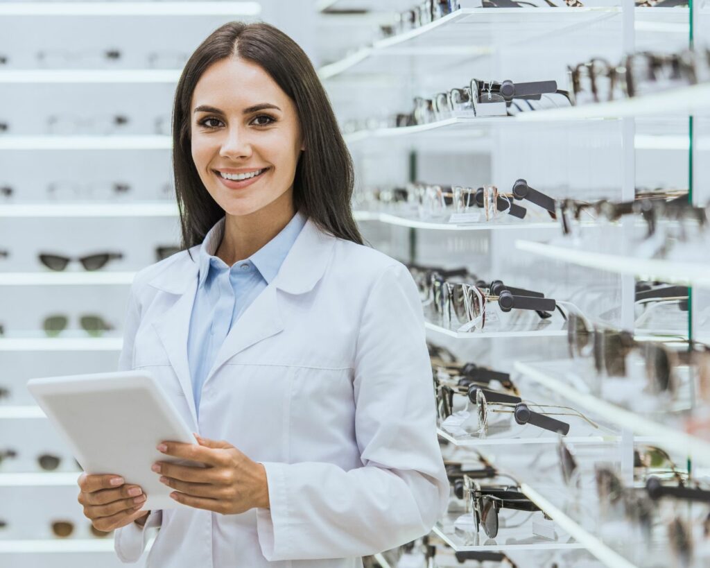 Opticienne devant un présentoir à lunettes