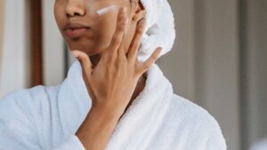 Femme qui se met de la crème sur le visage