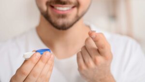 Homme qui met ses lentilles de contact