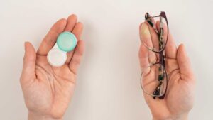Boîte de rangement pour les lentilles de contact dans une main et lunettes dans une autre