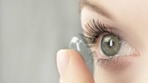 Femme qui se met une lentille dans les yeux