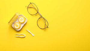Lentilles de contact avec lunettes de vues sur un fond jaune