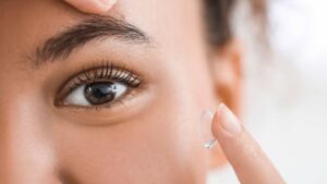 Femme qui se met une lentille dans les yeux