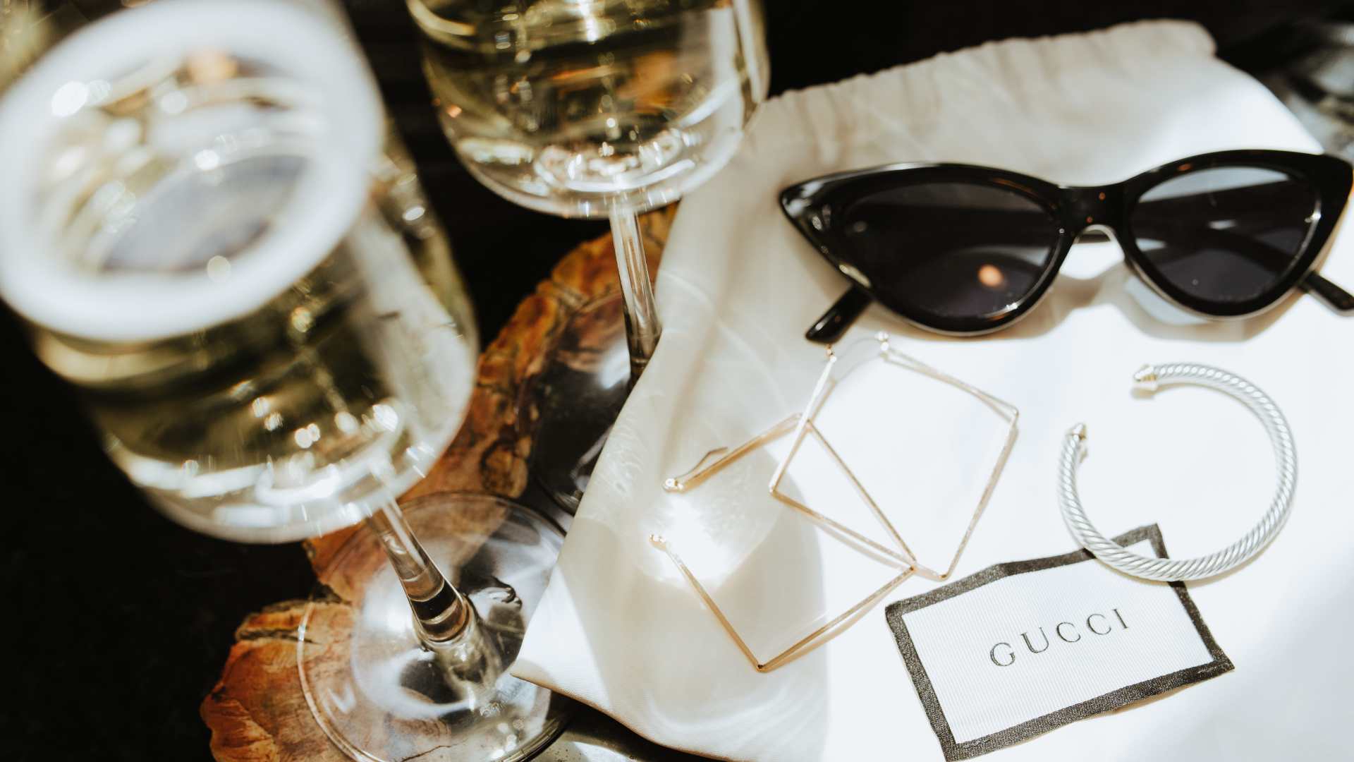 Lunettes Gucci sur une table avec des verres de champagne