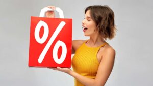 Femme qui tient un sac en papier rouge avec le signe des pourcentages