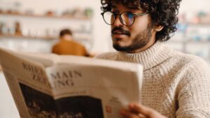 Homme avec une paire de lunettes qui lit un journal
